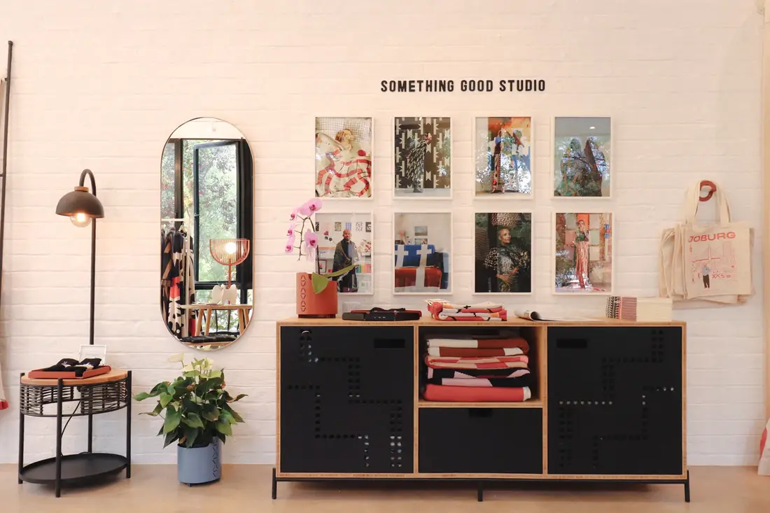 Inside Something Good Studio: prints and textiles on the wall above a black cabinet